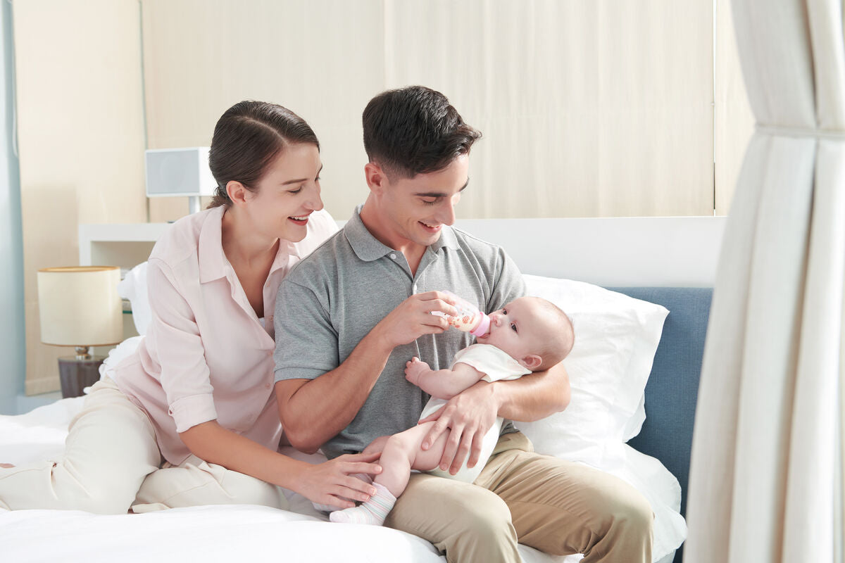 parents feeding baby with a bottle